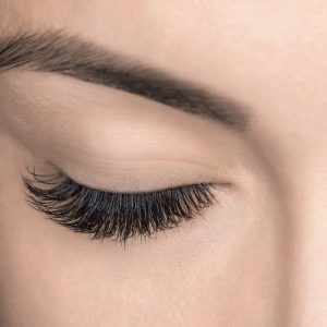 Eyelash removal procedure before and after close up. Beautiful Woman with long lashes in a beauty salon. Eyelash extension.